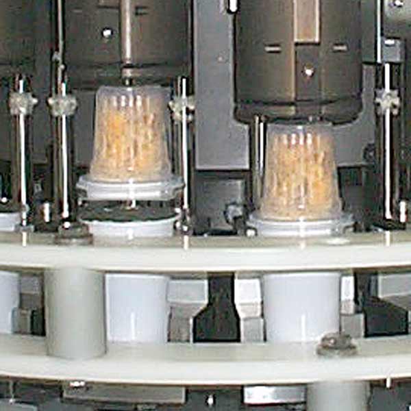 Two cereal cups in machine being processed.