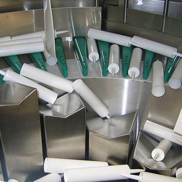 A collection of calk containers being in a machine.